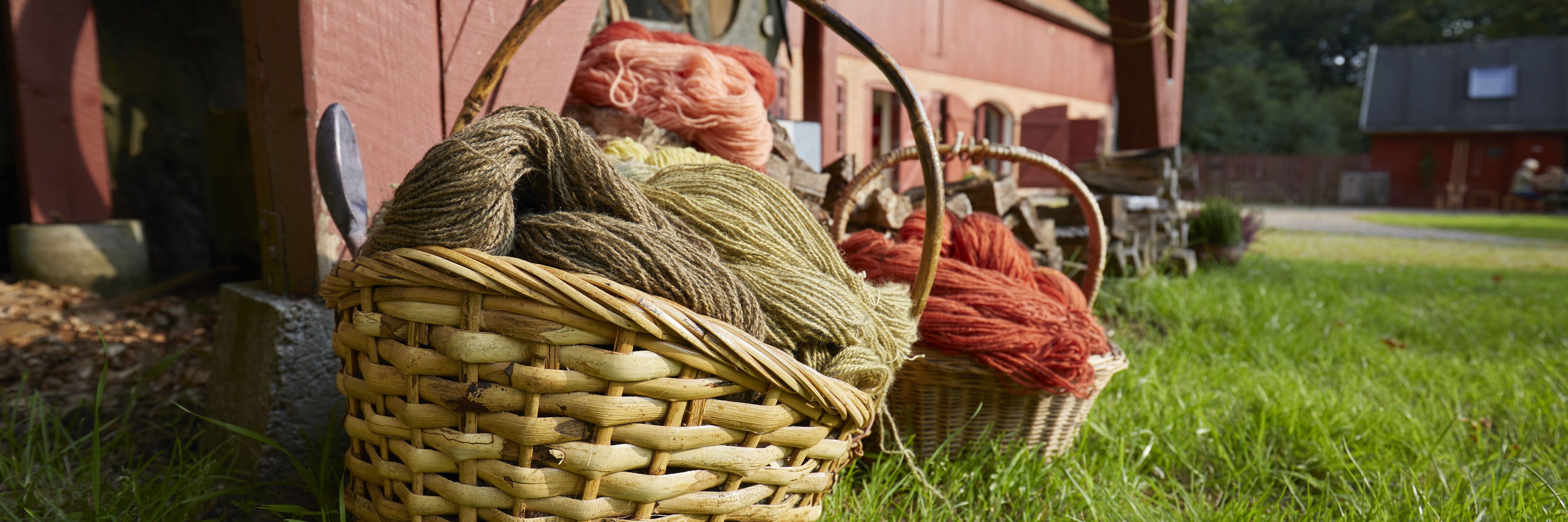 Kurve med håndfarvet garn foran Randbøldalmuseet